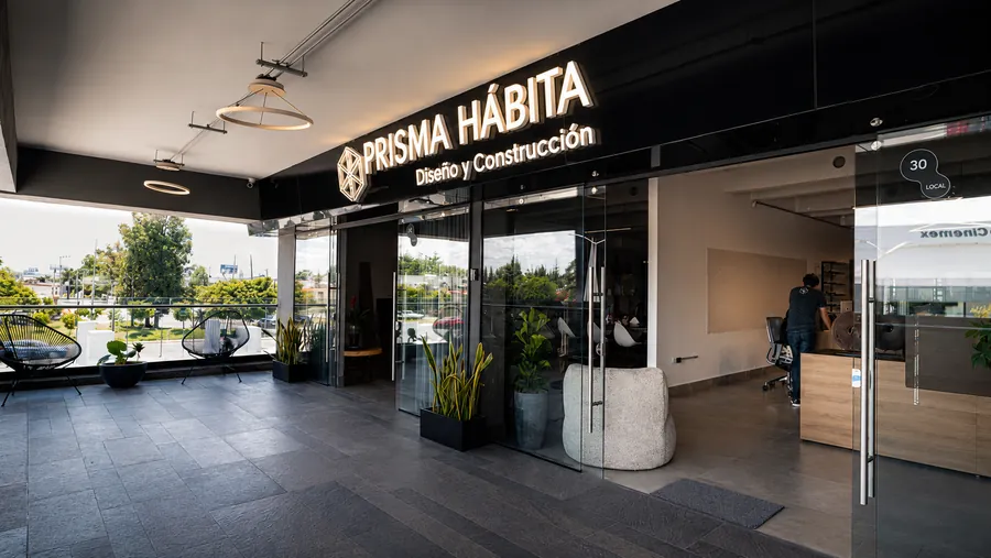 Entrada y terraza del estudio Prisma Habita en Puebla, con el letrero iluminado