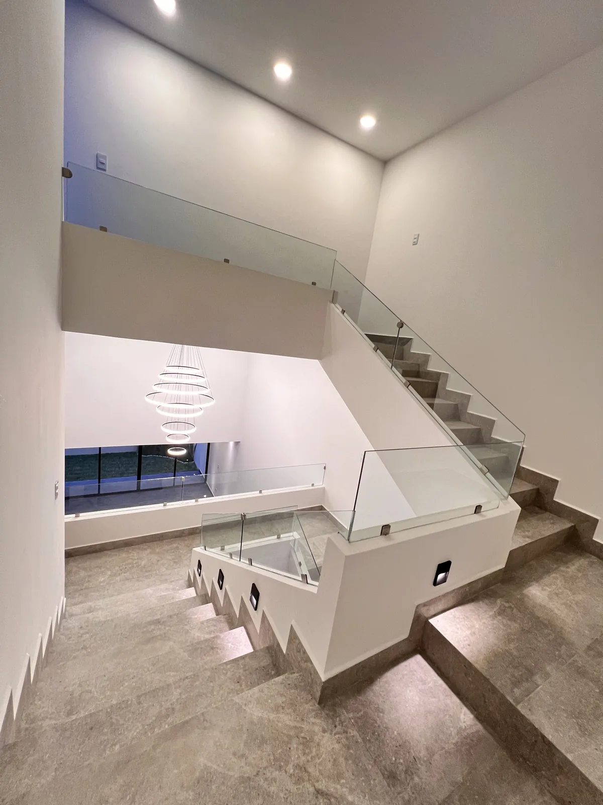 Escalera a doble altura con candil esférico — residencia contemporánea a la medida en Puebla