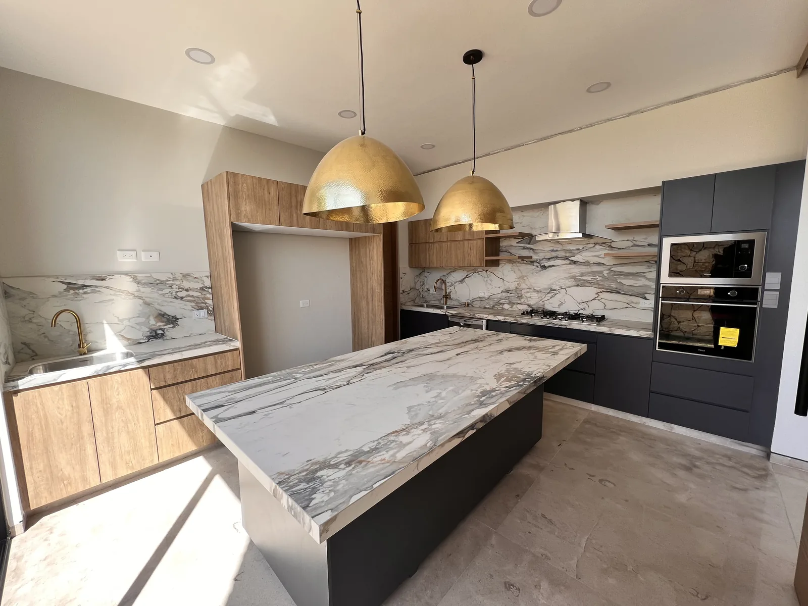 Cocina con isla de mármol en una residencia de Angelópolis, Puebla